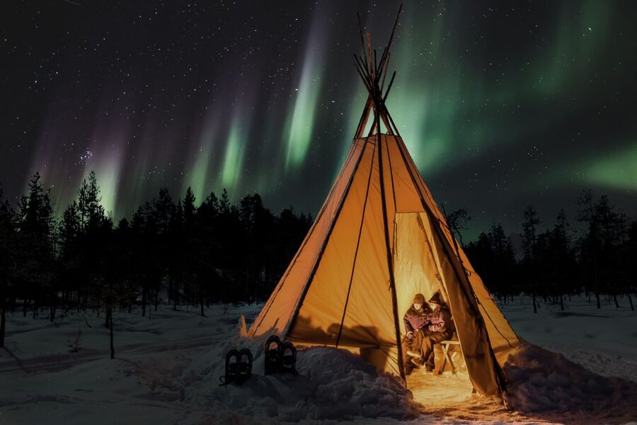 Levi: Northern Lights Campfire - Settling beside the fire in Finnish Lapland