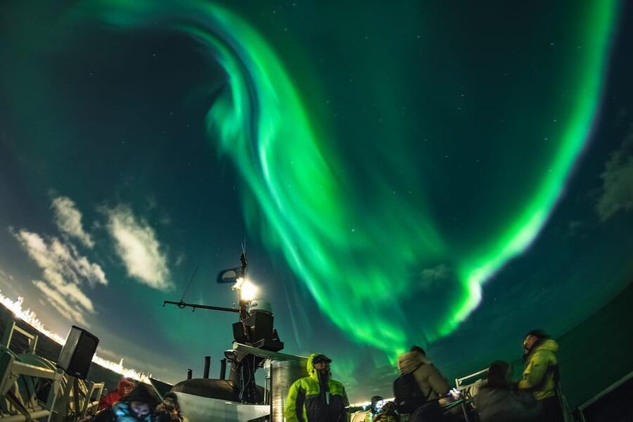 Reykjavik: Northern Lights Guided Boat Tour with Photos - Watching the sky with Reykjavik behind you