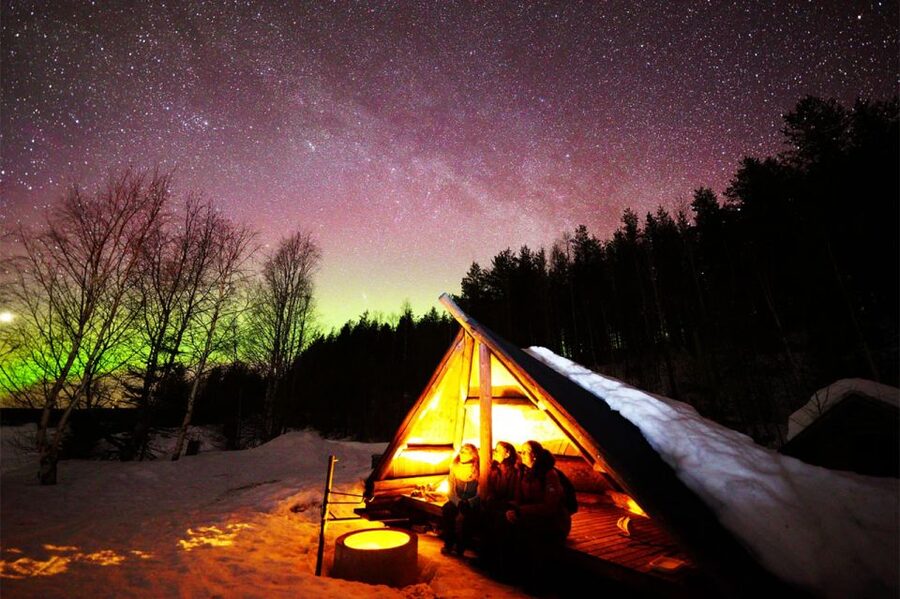 A green aurora band over a frozen lake in Finnish Lapland